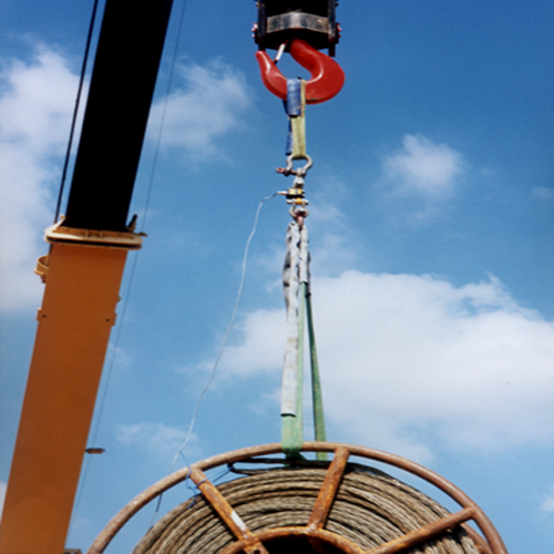 A large coil is lifted and weighed with crane